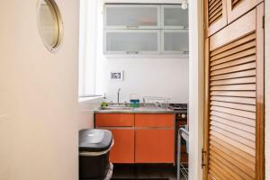 eine kleine Küche mit orangefarbenen Schränken und einem Waschbecken in der Unterkunft Increible departamento en la del valle in Mexiko-Stadt