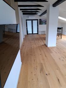 ein leeres Zimmer mit Holzboden und weißen Wänden in der Unterkunft GAMSI Apartment in Ljubljana