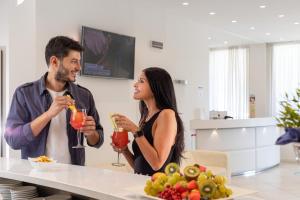 a man and woman drinking cocktails in a kitchen at Hb Hotels Orchidea Blu in Rimini