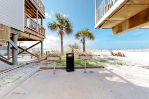 un cubo de basura en la playa con palmeras en Sunchase #208, en Gulf Shores