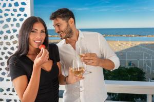 a man and a woman holding glasses of wine at Hb Hotels Orchidea Blu in Rimini