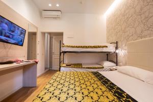 a bedroom with two bunk beds and a tv at Hb Hotels Orchidea Blu in Rimini