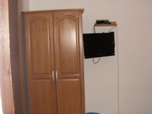 a wooden cabinet with a television on a wall at Guest House Korana in Korana