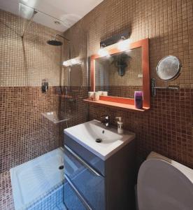 uma casa de banho com um lavatório, um WC e um espelho. em Au bout du pré em Pézenas