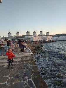 a little child standing next to a body of water at Terra Nova in Mýkonos City