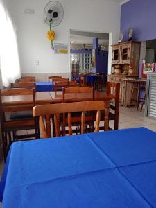 a dining room with blue tables and wooden chairs at Pousada Sereia Jofisa in Itanhaém