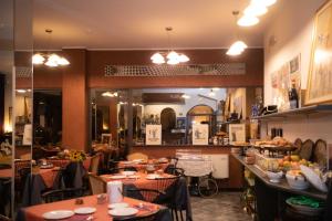 a restaurant with tables and chairs and a kitchen at Hotel Magnolia in Albenga