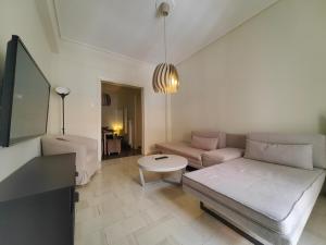 salon z kanapą i stołem w obiekcie Demetra - Koukaki center apartment w Atenach