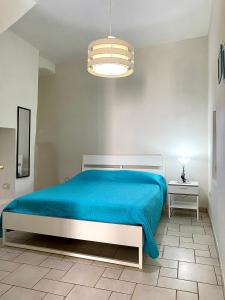 モノーポリにあるRosa Bianca - Puglia Mia Apartmentsのベッドルーム1室(青い毛布付きのベッド1台付)