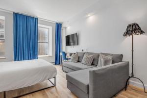 ケベック・シティーにあるInitial / Icone / Quebec+statのベッドルーム1室(ベッド1台、ソファ、青いカーテン付)