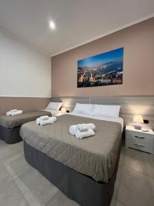 a bedroom with two beds with towels on them at Silvana Appartamento in Naples