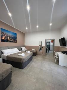 a hotel room with two beds and a desk at Silvana Appartamento in Naples