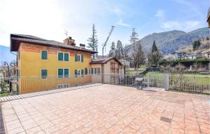 a large patio in front of a yellow house at Beautiful Apartment In Roncegno Terme With Wifi And 2 Bedrooms in Marter di Roncegno