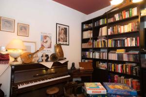 una stanza con pianoforte e libreria con libri di Hotel Magnolia ad Albenga