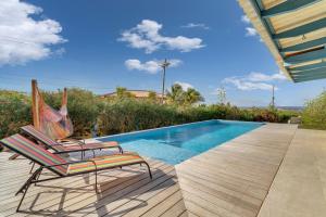 eine Terrasse mit einem Stuhl und einem Pool in der Unterkunft Goood Resort in Kralendijk