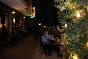 a man sitting in a chair in a restaurant at night at Hotel Magnolia in Albenga