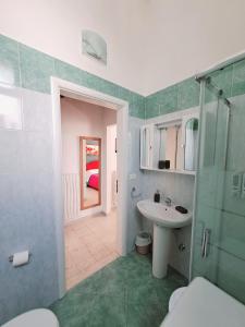 uma casa de banho com um lavatório, um chuveiro e um WC. em La Casa del Borgo em Lecce