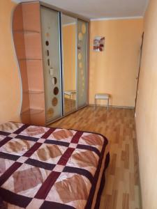 een slaapkamer met een bed en een spiegel bij Квартира в центрі на Волі 8 in Loetsk