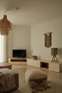 - un salon avec une télévision et un canapé dans l'établissement Casa Terra with Pool & Free WiFi, à Albufeira