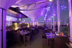 a restaurant with purple lighting and tables and chairs at Citrus Hotel Cunningham in Bangalore