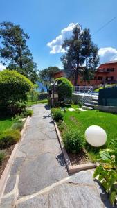 a stone walkway with a white frisbee on the grass at Quater Apartments - Tremezzina in Mezzegra