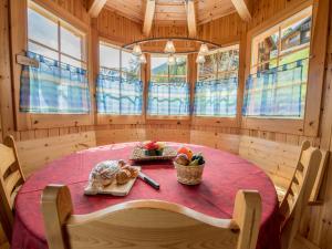 a dining room with a table in a room with windows at Chalet Colonia in La Tzoumaz
