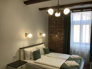 a bedroom with a bed and a brick wall at Casa Wagner in Sibiu