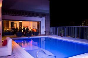 una piscina por la noche con gente de fondo en Crowne Plaza Asunción, an IHG Hotel, en Asunción