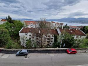 two cars parked in a parking lot in front of buildings at Apartment ILLARIA in Rijeka
