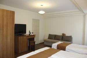 Habitación de hotel con 2 camas y TV de pantalla plana. en 5th Floor Guest House Yerevan, en Ereván