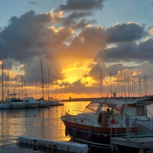 a boat docked in a marina with a sunset at "Il principio di Archimede"guest & art house in Siracusa