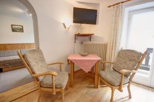 uma sala de estar com duas cadeiras, uma mesa e uma televisão em Bräulerhof em Bayerisch Gmain