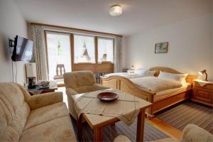 a bedroom with a bed and a couch and a table at Bräulerhof in Bayerisch Gmain