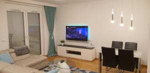 a living room with a couch and a tv on a wall at River Deluxe Atal Towers Apartment in Wrocław