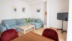 sala de estar con sofá azul y 2 sillas rojas en Apartamento Tomillo I, en Candeleda