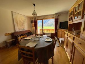 a dining room with a table with chairs and a couch at Appartement Samoëns, 2 pièces, 5 personnes - FR-1-624-37 in Samoëns