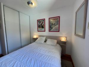 a bedroom with a white bed with two lamps at Appartement Samoëns, 2 pièces, 5 personnes - FR-1-624-37 in Samoëns