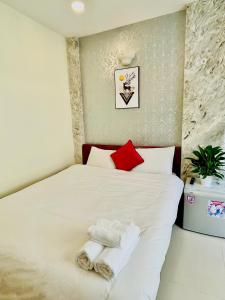 ein Schlafzimmer mit einem weißen Bett und Handtüchern darauf in der Unterkunft Dalat Colico Hotel in Da Lat