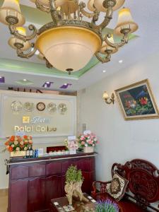 Dalat Colico Hotel في دالات: وجود ثريا في صالون مع طاولة وكراسي