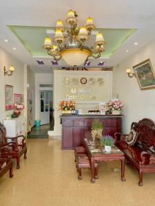 ein Wohnzimmer mit einem Tisch, Stühlen und einem Kronleuchter in der Unterkunft Dalat Colico Hotel in Da Lat