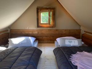 a bedroom with two beds and a window at Camping Calme et Nature Iserand in Vion