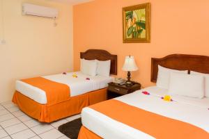 a hotel room with two beds and a lamp at Bay Gardens Inn in Gros Islet