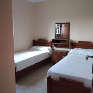 sypialnia z 2 łóżkami z lustrem i komodą w obiekcie Addas Home w mieście Siwa