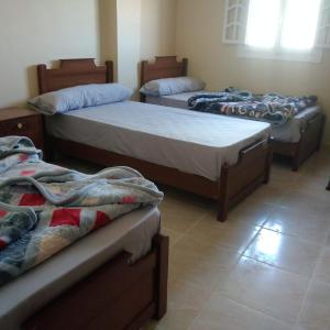 a room with three beds in a room at Addas Home in Siwa