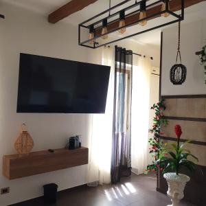 un soggiorno con una grande TV a schermo piatto a parete di B&B Idrotaras a Taranto