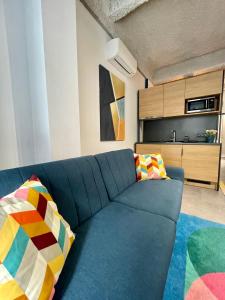 a blue couch with colorful pillows in a living room at Design Boutique INBP109 Studio Apartment #freeparking in Budapest