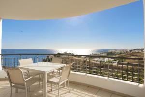 een balkon met een tafel en stoelen en de oceaan bij Apartamento vista mar lateral in Torrox Costa