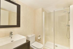 een badkamer met een toilet, een wastafel en een douche bij Apartamento vista mar lateral in Torrox Costa +8 foto's