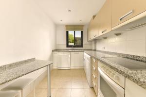 een grote keuken met witte kasten en een wastafel bij Apartamento vista mar lateral in Torrox Costa