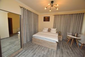 a bedroom with a bed and a table and a mirror at Altunyan Hotel in Yerevan